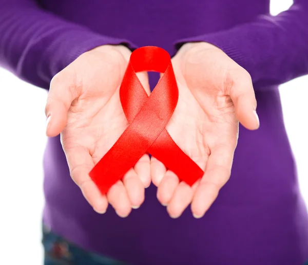 Woman is holding the red awareness ribbon — Stock Photo, Image