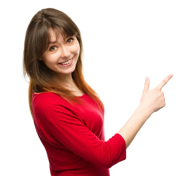 Portrait of a young woman pointing to the right — Stock Photo, Image