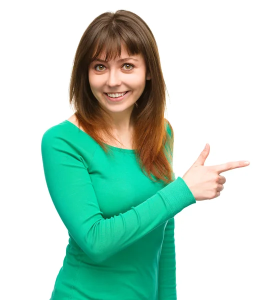 Portrait of a young woman pointing to the right — Stock Photo, Image