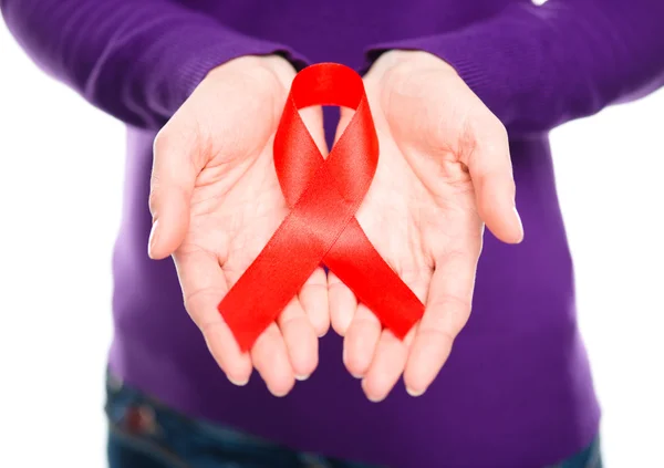 Woman is holding the red awareness ribbon — Stock Photo, Image