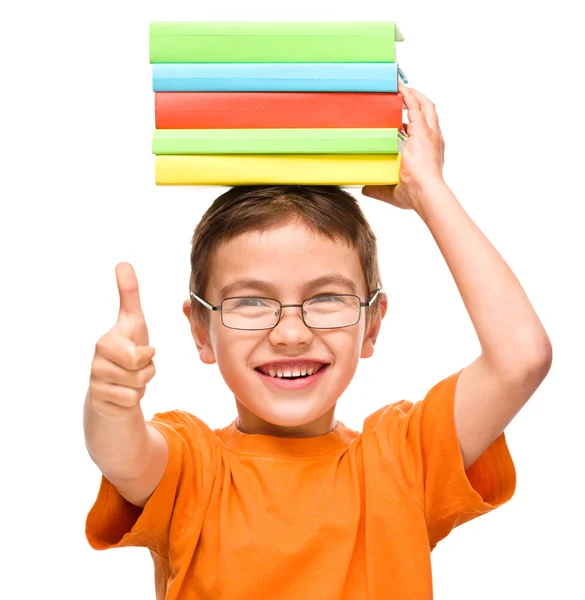 Mały chłopiec trzyma stos książek — Zdjęcie stockowe
