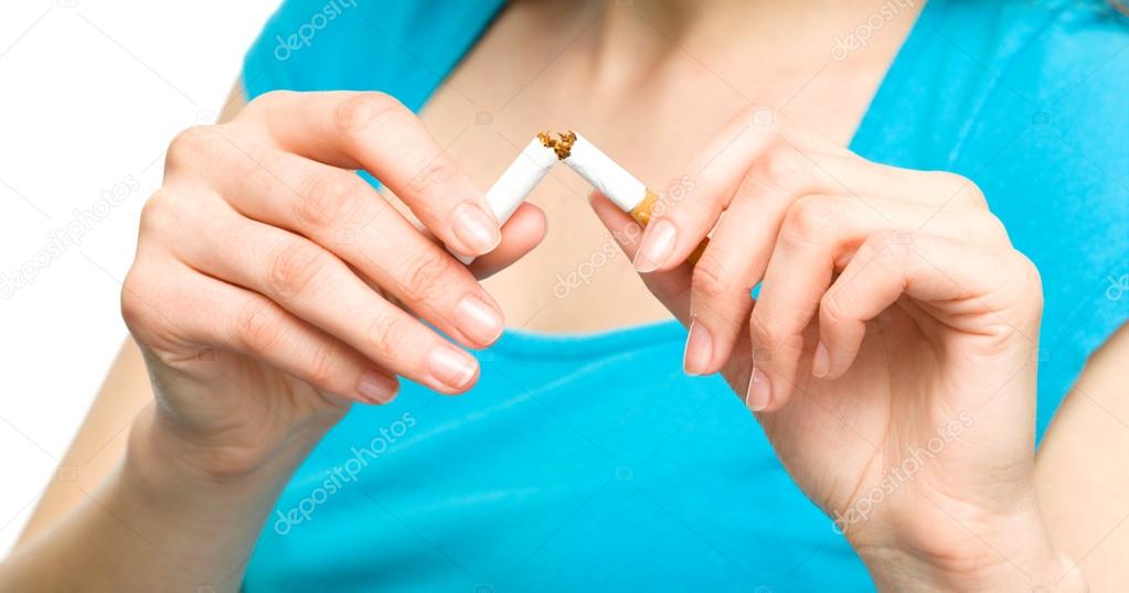 Young woman is breaking a cigarette