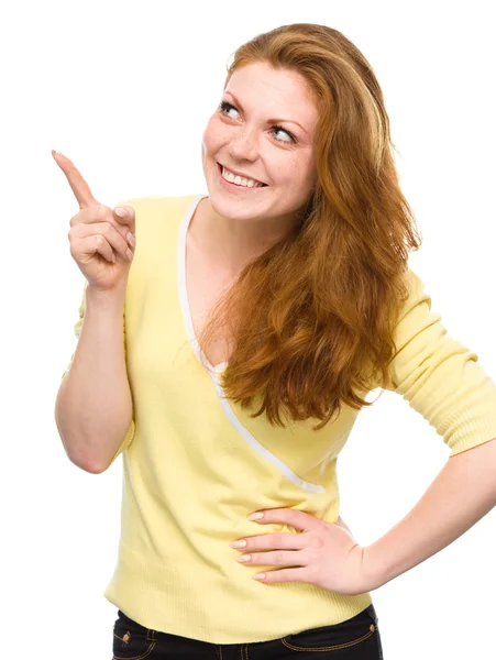 Portrait of a young woman pointing to the left — Stock Photo, Image