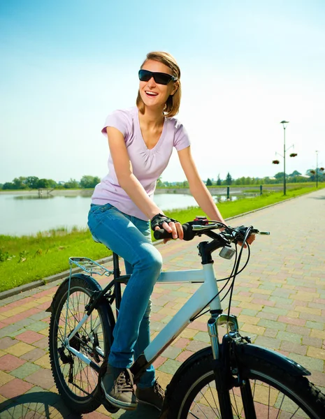 Młoda kobieta siedzi na jej rower — Zdjęcie stockowe