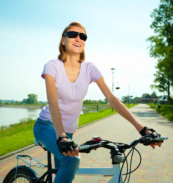 Mujer joven está sentada en su bicicleta —  Fotos de Stock