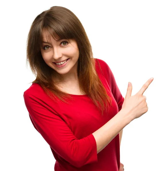 Portrait of a young woman pointing to the right — Stock Photo, Image