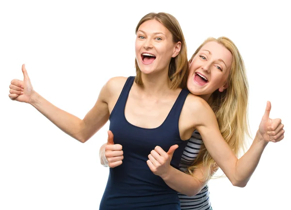 Две молодые счастливые женщины показывают большой палец вверх знак — стоковое фото