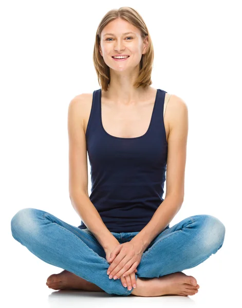 Young happy woman is sitting on the floor — Stock Photo, Image