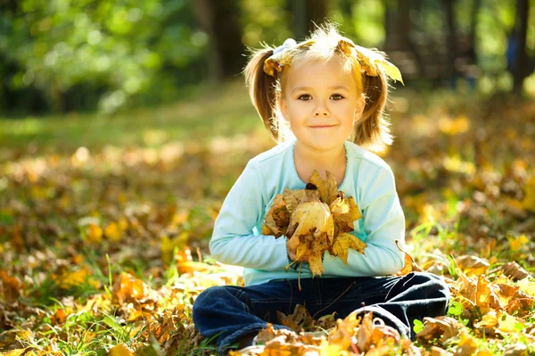 Porträtt av en liten flicka i höst park — Stockfoto