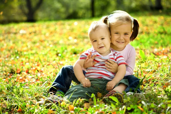 Children are playing in autumn park — Stock Photo, Image