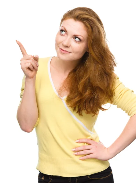 Portrait of a young woman pointing to the right — Stock Photo, Image