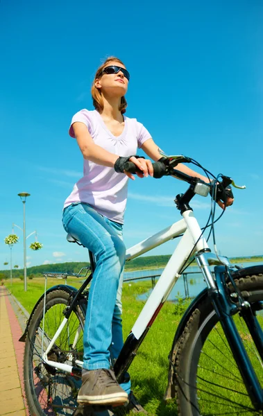 Νεαρή γυναίκα κάθεται με το ποδήλατο — Φωτογραφία Αρχείου