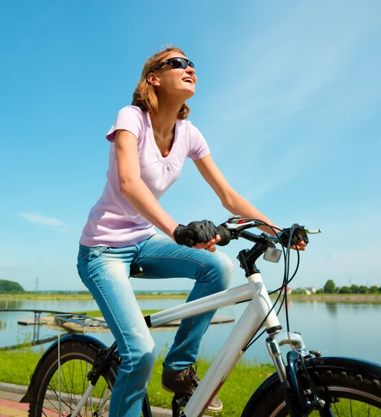 Jovem mulher está sentada em sua bicicleta — Fotografia de Stock