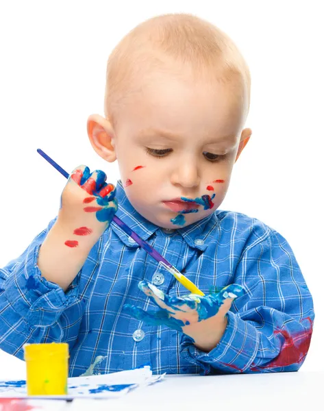 Menino está brincando com tintas — Fotografia de Stock