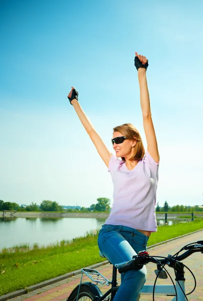 Mujer joven está sentada en su bicicleta — Foto de Stock