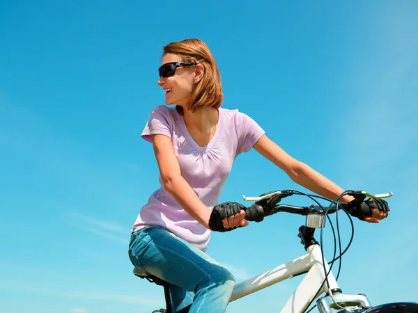 Mujer joven está sentada en su bicicleta — Foto de Stock