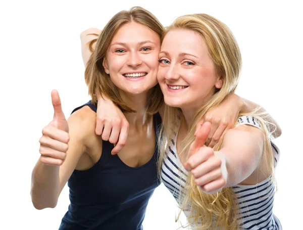 Dos jóvenes mujeres felices mostrando el pulgar hacia arriba signo — Foto de Stock