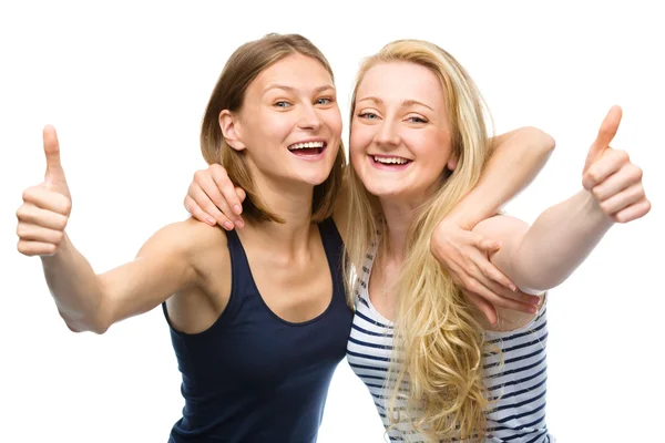 两个年轻快乐的女人显示大拇指标志 — 图库照片