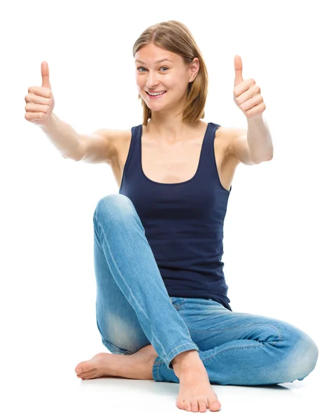 Jovem mulher feliz está mostrando sinal de polegar para cima — Fotografia de Stock