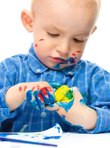 Menino está brincando com tintas — Fotografia de Stock