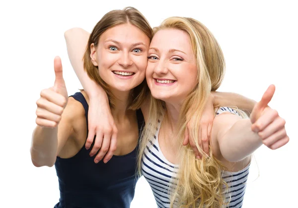 Two young happy women showing thumb up sign — Stock Photo, Image