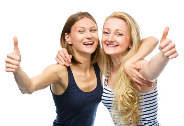 Дві молоді щасливі жінки показують великий палець знак — стокове фото
