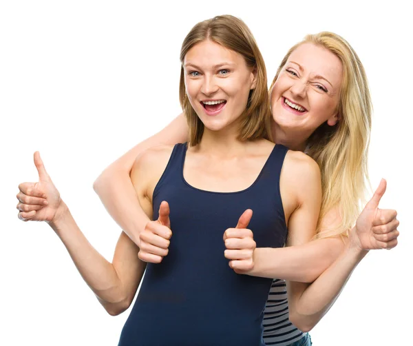 Dos jóvenes mujeres felices mostrando el pulgar hacia arriba signo — Foto de Stock