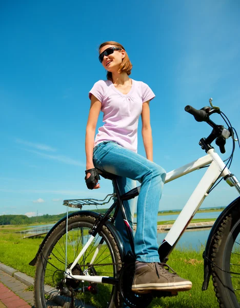Giovane donna è seduta sulla sua bicicletta — Foto Stock