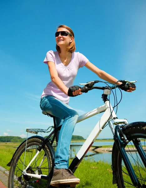 Mujer joven está sentada en su bicicleta —  Fotos de Stock