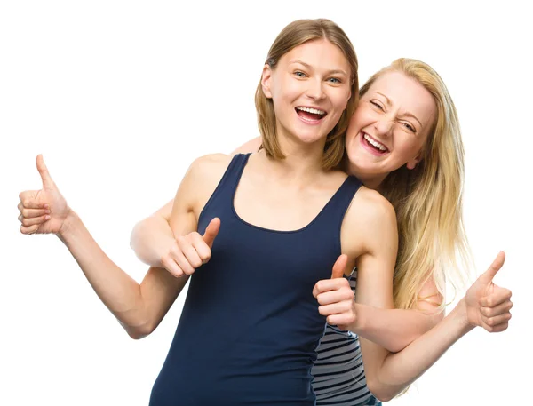 Дві молоді щасливі жінки показують великий палець знак — стокове фото