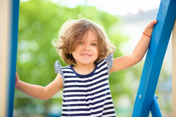 Linda niña está jugando en el patio de recreo —  Fotos de Stock