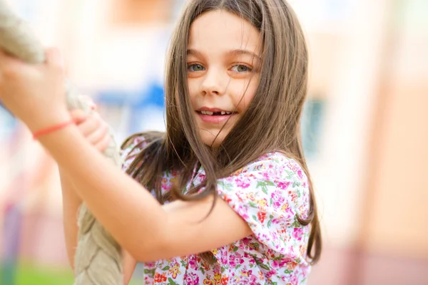 Linda niña está jugando en el patio de recreo — Foto de Stock