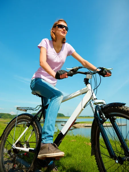 Mujer joven está sentada en su bicicleta —  Fotos de Stock