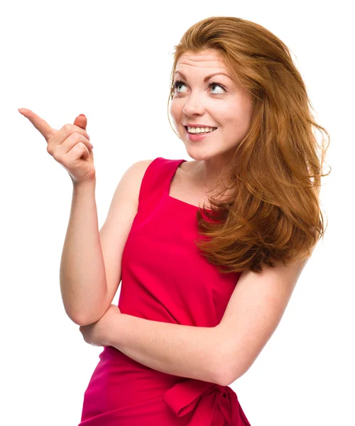 Portrait of a young woman pointing to the left — Stock Photo, Image