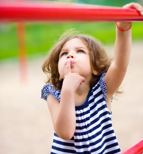 Menina bonito está jogando no parque infantil — Fotografia de Stock
