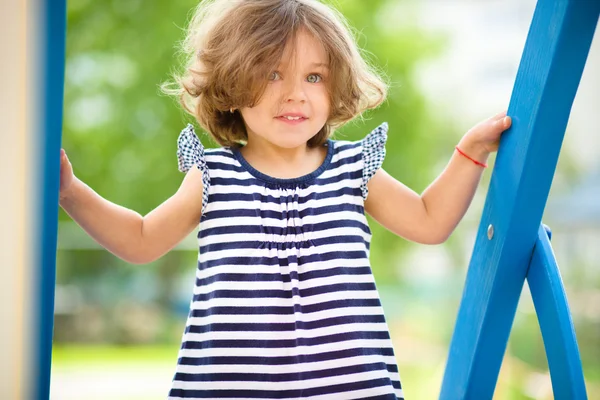 Linda niña está jugando en el patio de recreo —  Fotos de Stock