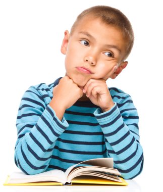 genç çocuk kitap okurken hayal ediyor