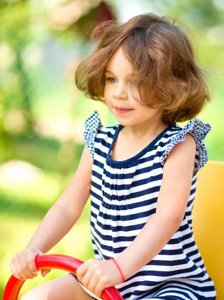 Junges glückliches Mädchen schaukelt auf Spielplatz — Stockfoto