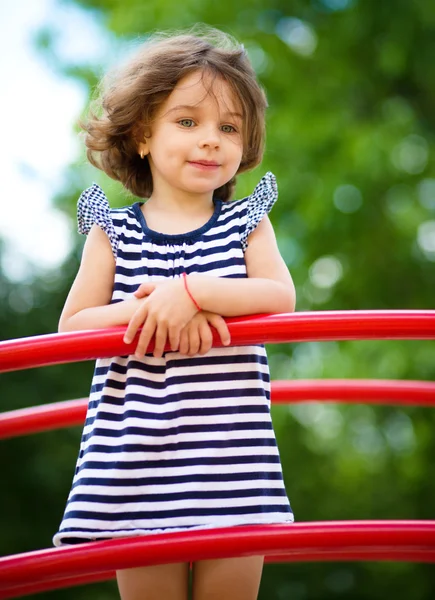 Милая маленькая девочка играет на детской площадке — стоковое фото