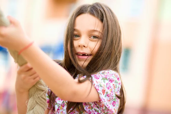 Menina bonito está jogando no parque infantil — Fotografia de Stock