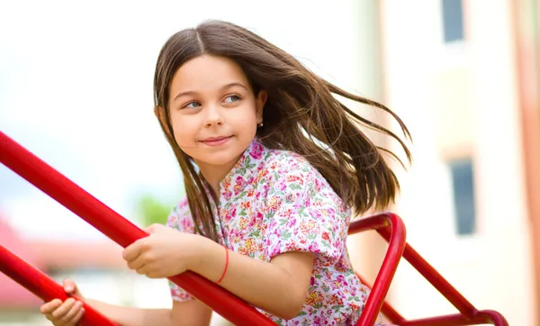 Young happy girl is swinging in playground — Stock Photo, Image