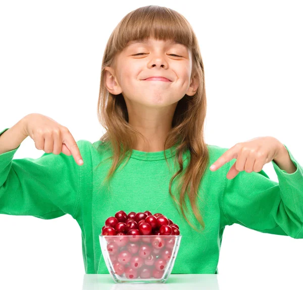 Cute girl is eating cherries — Stock Photo, Image
