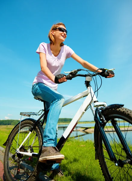 Genç kadın onun bisiklet üzerinde oturuyor — Stok fotoğraf