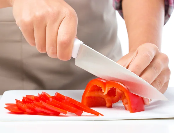 Cozinheiro está cortando pimentão — Fotografia de Stock