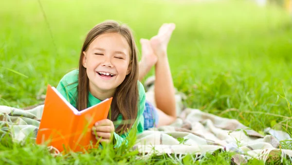 Petite fille lit un livre en plein air — Photo