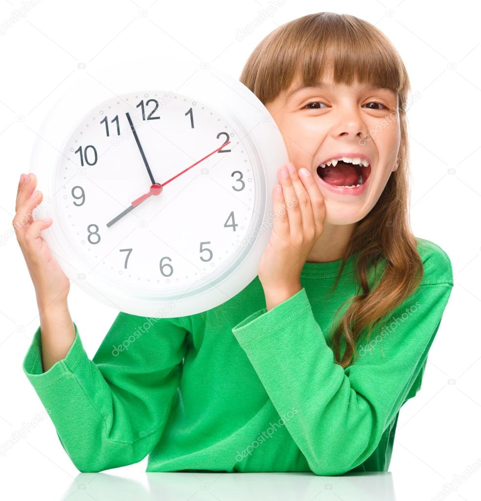 Little girl is holding big clock