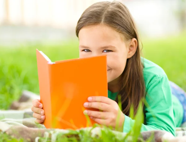 Dziewczynka jest czytanie książki na zewnątrz — Zdjęcie stockowe