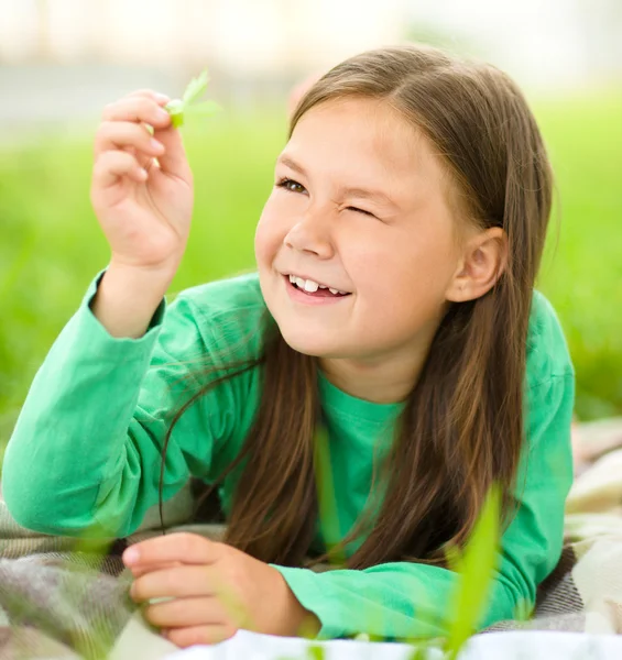 緑の芝生の上に敷設小さな女の子の肖像画 — ストック写真