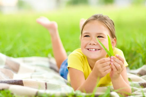 Yeşil çimenlerin üzerinde döşeme küçük bir kızın portresi — Stok fotoğraf