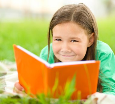 küçük kız açık havada bir kitap okuma